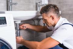 adult-plumber-fixing-sink-at-bathroom
