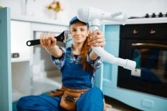 young-female-plumber-shows-wrench-and-pipe-1