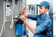 young-plumber-or-technician-installing-or-repairing-system-of-water-filtration